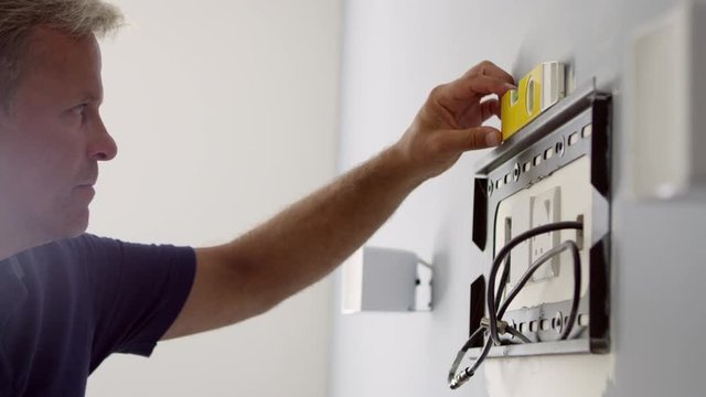 Man Fitting Bracket For Flat Screen TV Onto Wall Shot On R3D