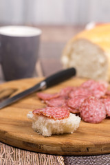 Sliced sausages on the wooden board with bread