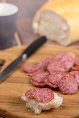 Sliced sausages on the wooden board with bread