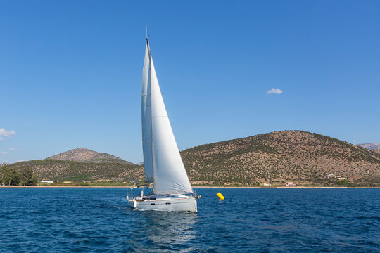 Sailing yachts boat with white sails in regatta at the sea.