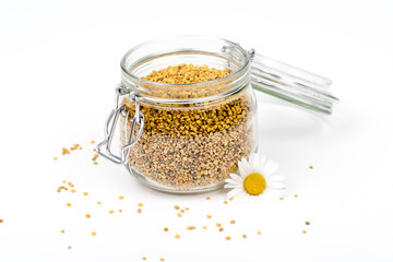 Closeup of bee pollen granules in glass jar. Health, healthy jar. Vitamin jar for immune system,  protection, energy. Daisy flower.Food ingredient for health,medical concept. Isolated,white background