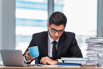 Young businessman drinking tea in the office