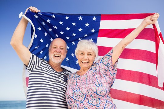 Senior couple holding american flag - Powered by Adobe