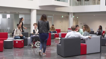 Low angle view of students in a busy university lobby area, shot on R3D