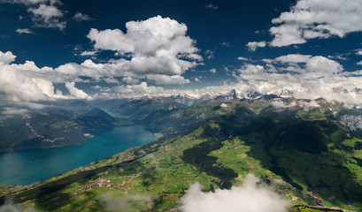 Aerial shot of Bernese Alps, lush valley and Lake of Thun, Berner Oberland, Switzerland. - 128554071