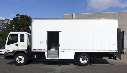 Side view of white delivery truck with side access door open. Horizontal.