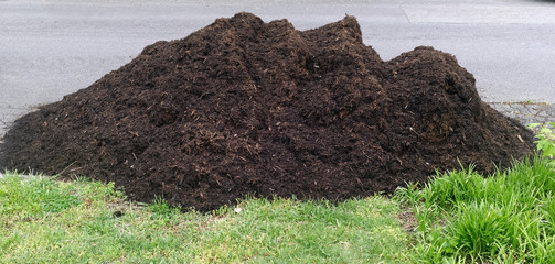 Spring mulch pile delivered to neighborhood home. Horizontal.