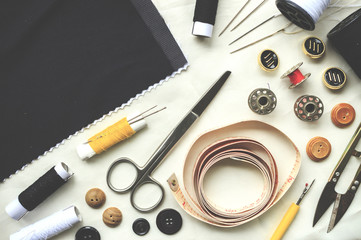 sewing tools on white fabric background. over light and high contrast