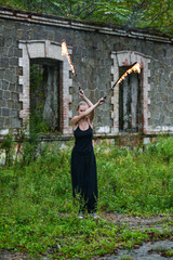 Girl in a black suit with flaming torches .