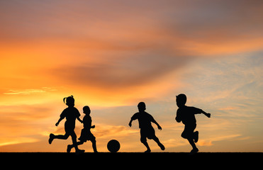 Fototapeta na wymiar children playing soccer at sunset.