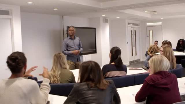 Male teacher talking with students in a university classroom, shot on R3D