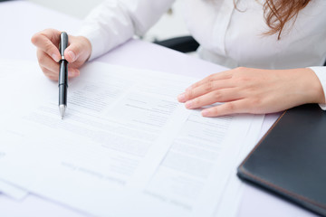 Business woman filling information on document.