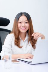 Young business woman using laptop at desk.