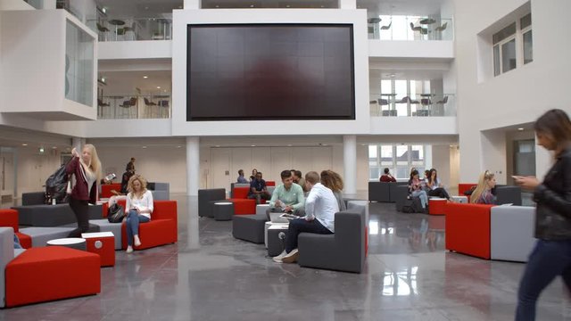 Students come and go in the busy lobby of a university