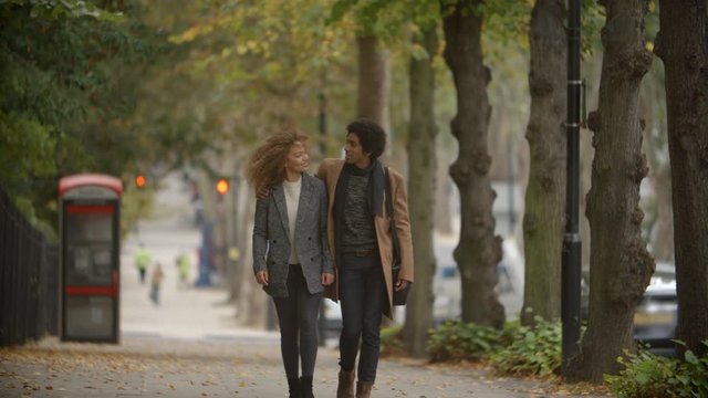 Romantic Couple Walk On Fall Street In City In Slow Motion