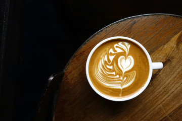 cup of latte art coffee on wooden background