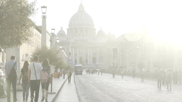 Many people walking brightly sunlit street, church in Vatican City, slow motion