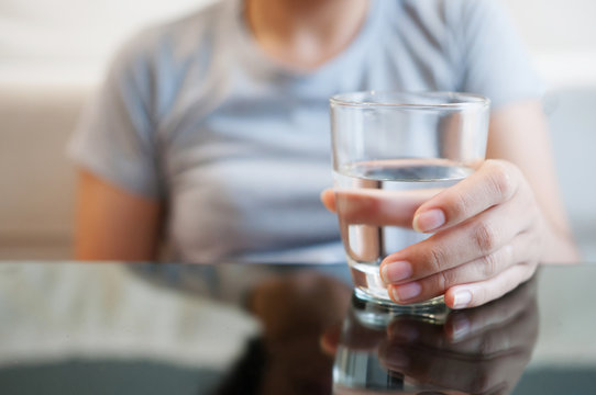Woman hand holding glass of water for drink.