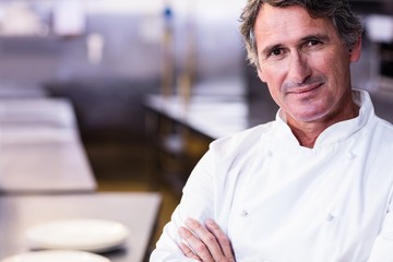 Smiling chef with hands crossed in the kitchen