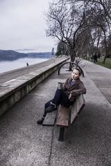 Woman relaxing on park bench.