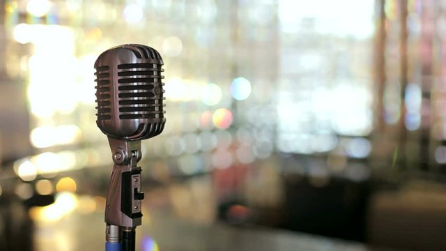 Beautiful vintage microphone In the interior of the cafe. Retro microphone on a bright background. Slow motion.