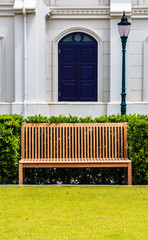 Wooden Bench in front of White Building and Street Lamp
