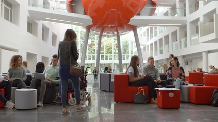 Students socialising in the lobby of a university, low angle