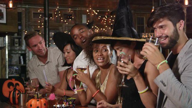 Friends enjoying a Halloween party at a bar making a toast, shot on R3D