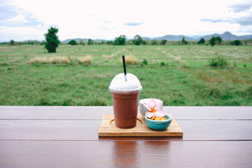 iced coffee and biscuit alphabet with rice field background