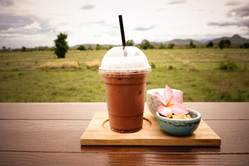 iced coffee and biscuit alphabet with rice field background