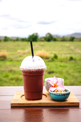 iced coffee and biscuit alphabet with rice field background