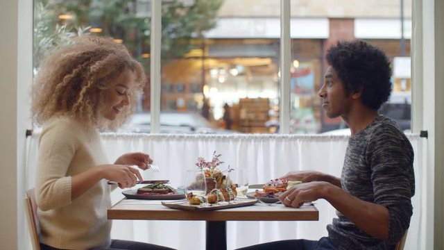 Young Couple Enjoying Meal On Date In City Restaurant