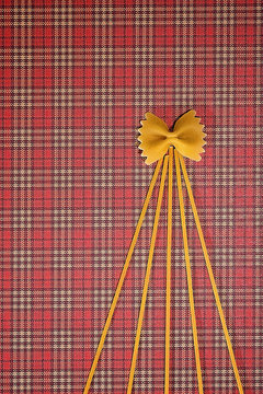 Christmas tree made of pasta on red squared background. Flat lay. Top view. Winter holidays concept