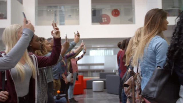 University students raising phones in unison to take a photo