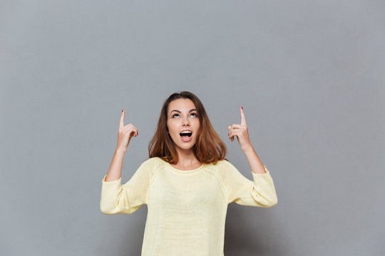 Young brunette woman pounting two fingers up at copyspace