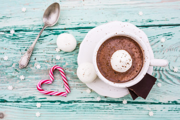 Delicious hot chocolate with marshmallows in a cup on a wooden table. 