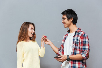 Couple listening to music with the same pair of earphones