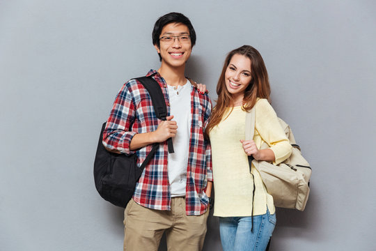 Young attractive students couple standing together with backpacks