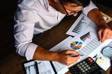 Analyzing financial data and counting on calculator.