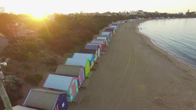 Slow rise right above Brighton Beach bathing huts at sunrise. Melbourne, Victoria, Australia