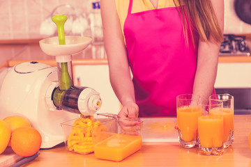 Obraz na płótnie Canvas Woman pouring orange juice drink in glass
