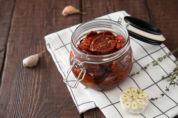Sun dried tomatoes with herbs and sea salt in olive oil in a gla