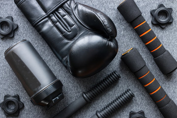 Boxing Glove, dumbbells and shaker on a gray background