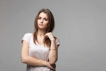 Fototapeta premium Portrait of beautiful brunette woman with natural make-up, on grey background