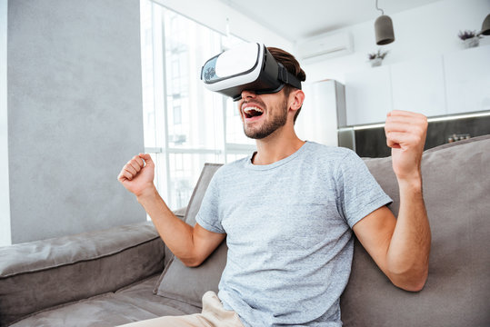Young Man Making Winner Gesture While Wearing Virtual Reality Device