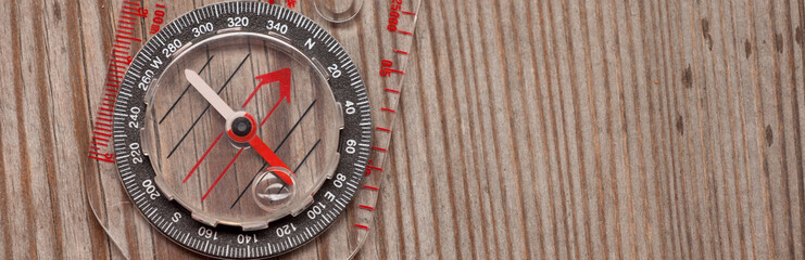 plastic compass over a wooden background