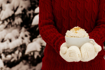 Women's hands holding a cup of hot drink