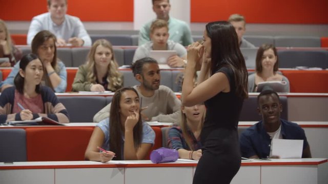 Female teacher and students in university lecture theatre