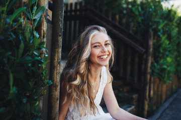 incredibly beautiful and happy girl sitting on the stairs