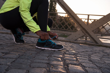 African american woman runner tightening shoe lace